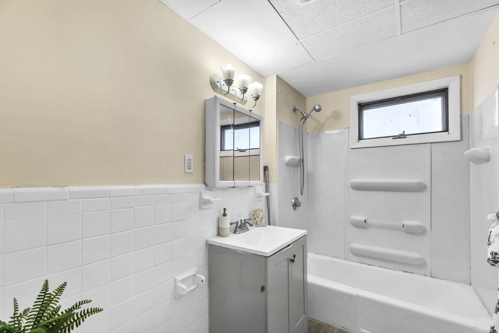 102 Florida Street Springfield, MA 01109 - Photo 19 of 45 a bathroom with a bathtub a shower a sink and mirror