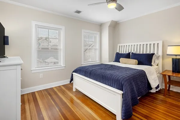 a spacious bedroom with a bed and wooden floor