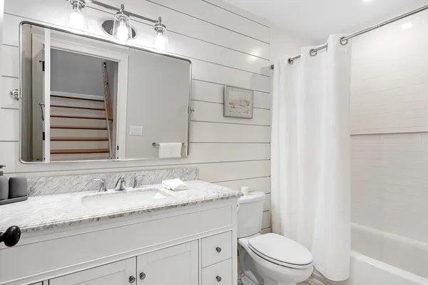 a bathroom with a granite countertop sink toilet and shower
