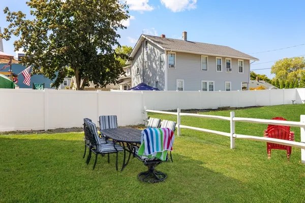 a view of a house with a yard and sitting area