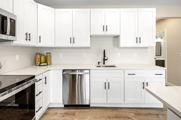 a kitchen with stainless steel appliances white cabinets and a sink