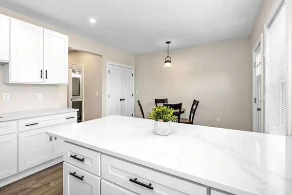 a kitchen with a white cabinets and chandelier