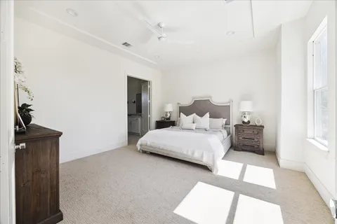 a bedroom with a large bed and a chandelier