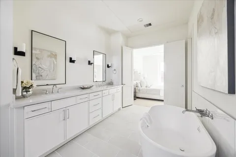 a spacious bathroom with a double vanity sink mirror and bathtub