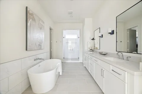 a spacious bathroom with a tub sink and mirror