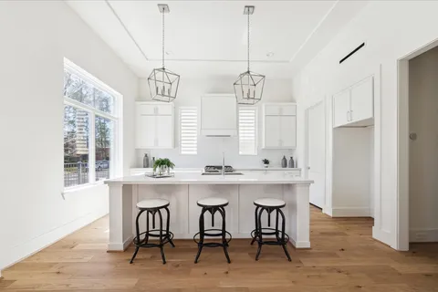 a kitchen with stainless steel appliances a sink and white cabinets