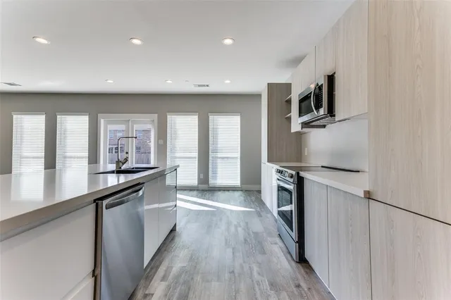a kitchen with stainless steel appliances a sink stove and refrigerator