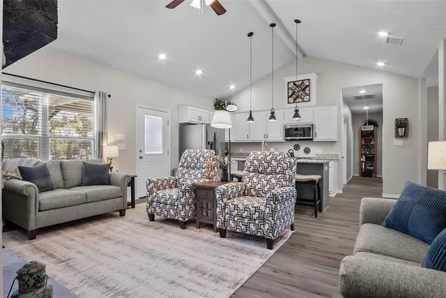 a living room with furniture kitchen and a large window
