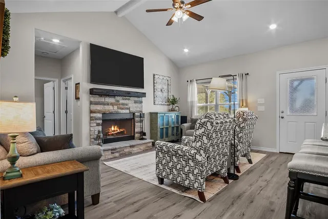 a living room with furniture a flat screen tv and a fireplace