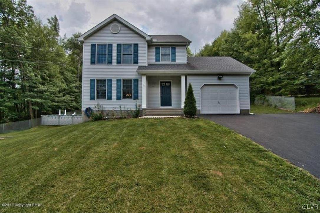 a front view of a house with a yard and trees