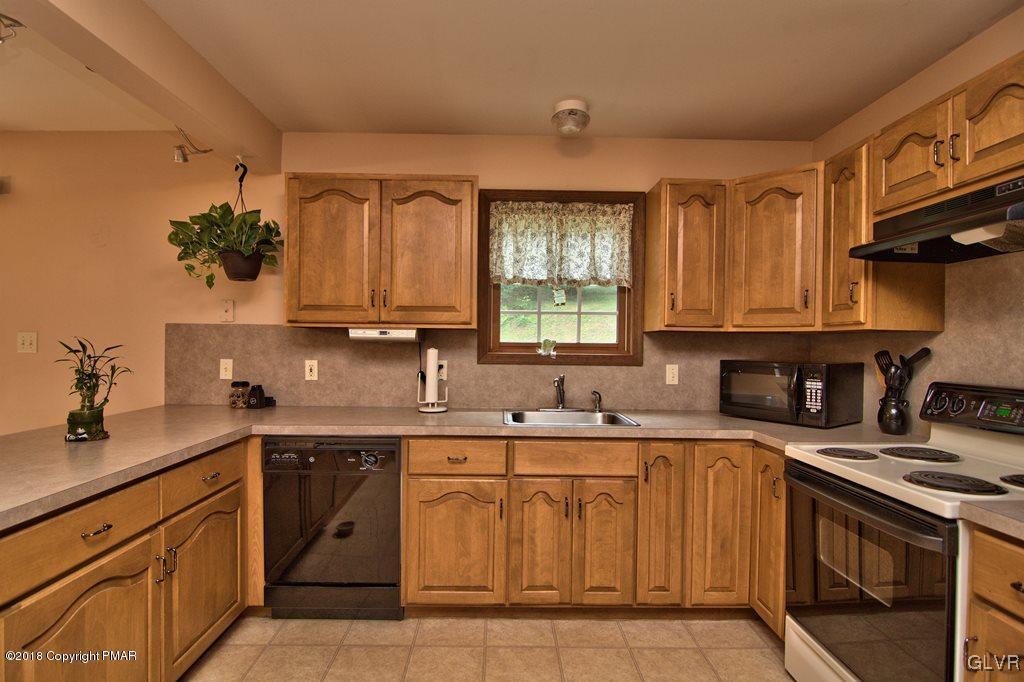 251 Devils Hole Road Cresco, PA 18326 - Photo 13 of 35 a kitchen with a sink stove and cabinets