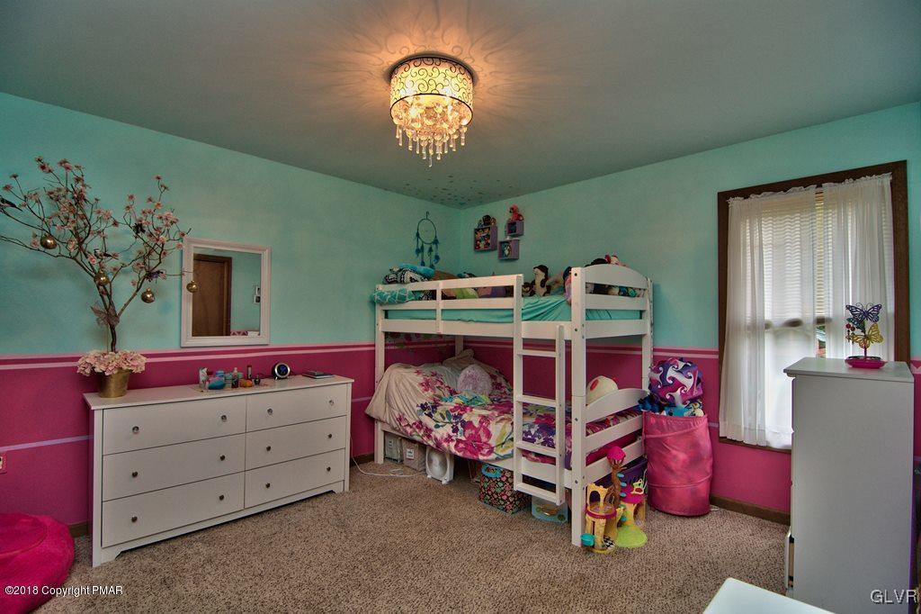 251 Devils Hole Road Cresco, PA 18326 - Photo 31 of 35 a bedroom with a bed and a chandelier