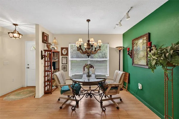 a dining room with furniture a potted plant and wooden floor
