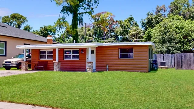 a view of a house with a yard and sitting area