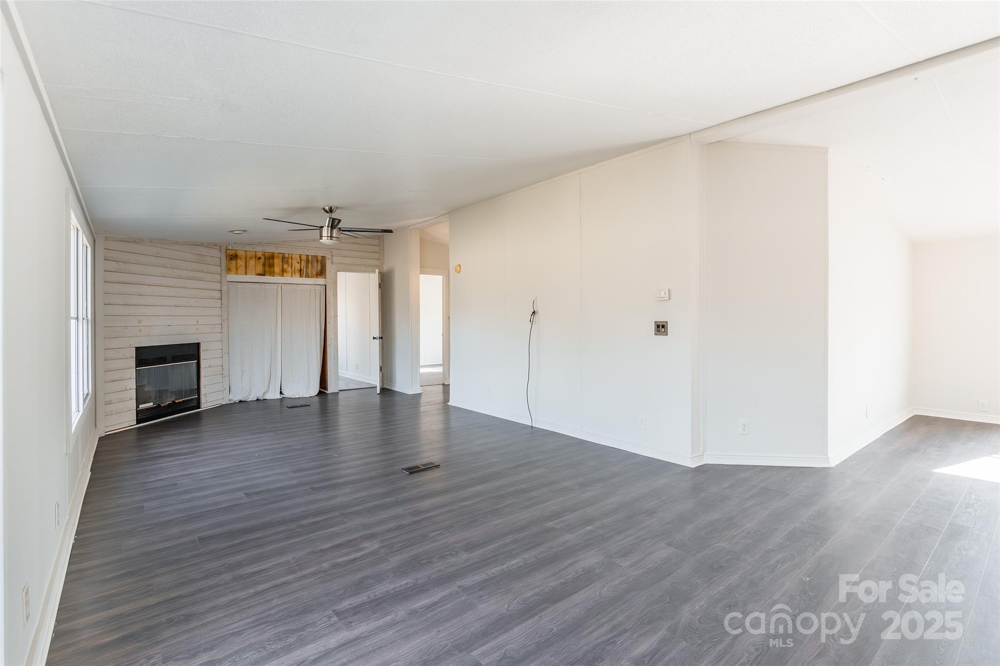 6315 Wingate Hill Road Denver, NC 28037 - Photo 8 of 21 an empty room with wooden floor fireplace and windows