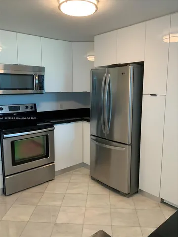 a kitchen with a stove top oven and refrigerator