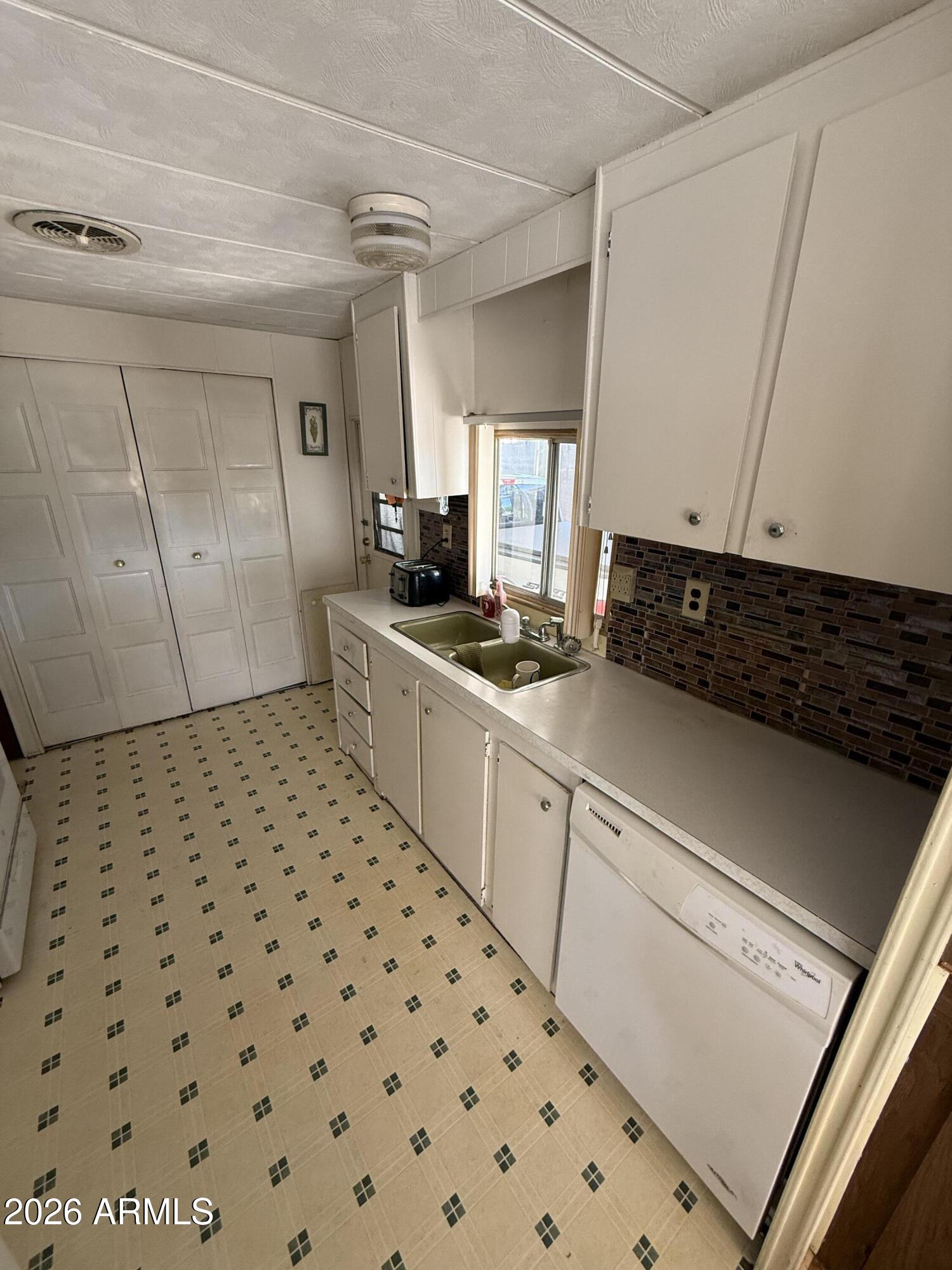 9501 East Broadway Road, Unit 164 Mesa, AZ 85208 - Photo 12 of 27 a kitchen with a sink a stove a refrigerator and cabinets