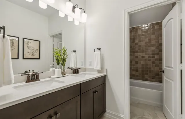 a bathroom with a double vanity sink a large mirror a bathtub and shower