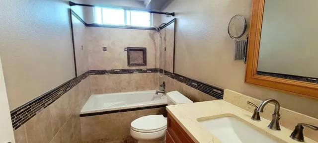 a bathroom with a sink a toilet and a mirror