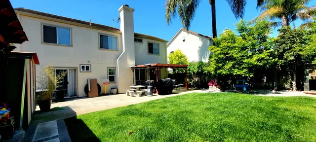 a view of a house with a yard and sitting area