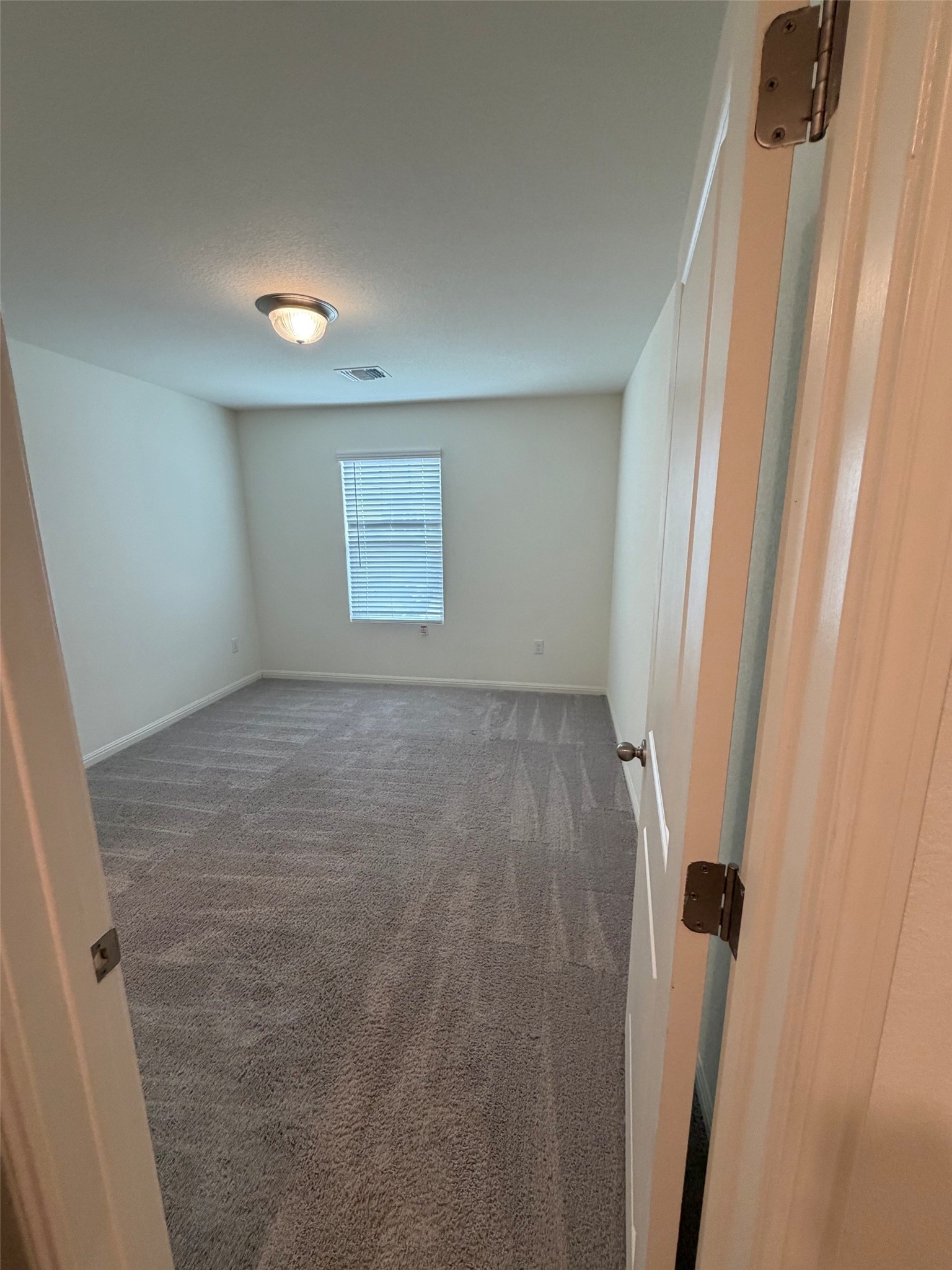 229-1 Night Riders Way Jarrell, TX 76537 - Photo 7 of 21 A well-lit, neutral-toned bedroom awaits your personal touch with soft, patterned carpeting underfoot.