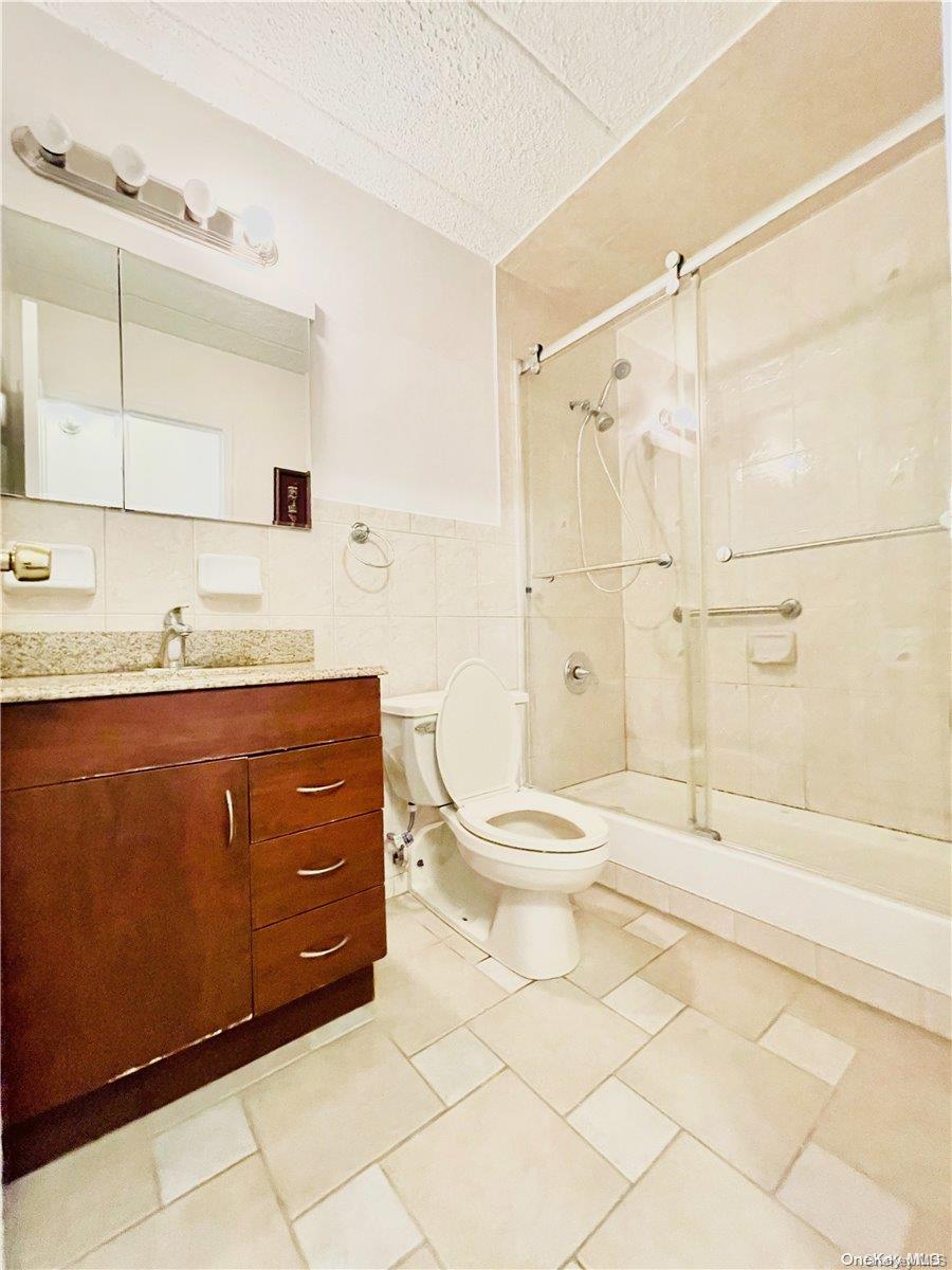 92-29 Queens Boulevard, Unit 9D Queens, NY 11374 - Photo 11 of 13 a bathroom with a sink a toilet and shower