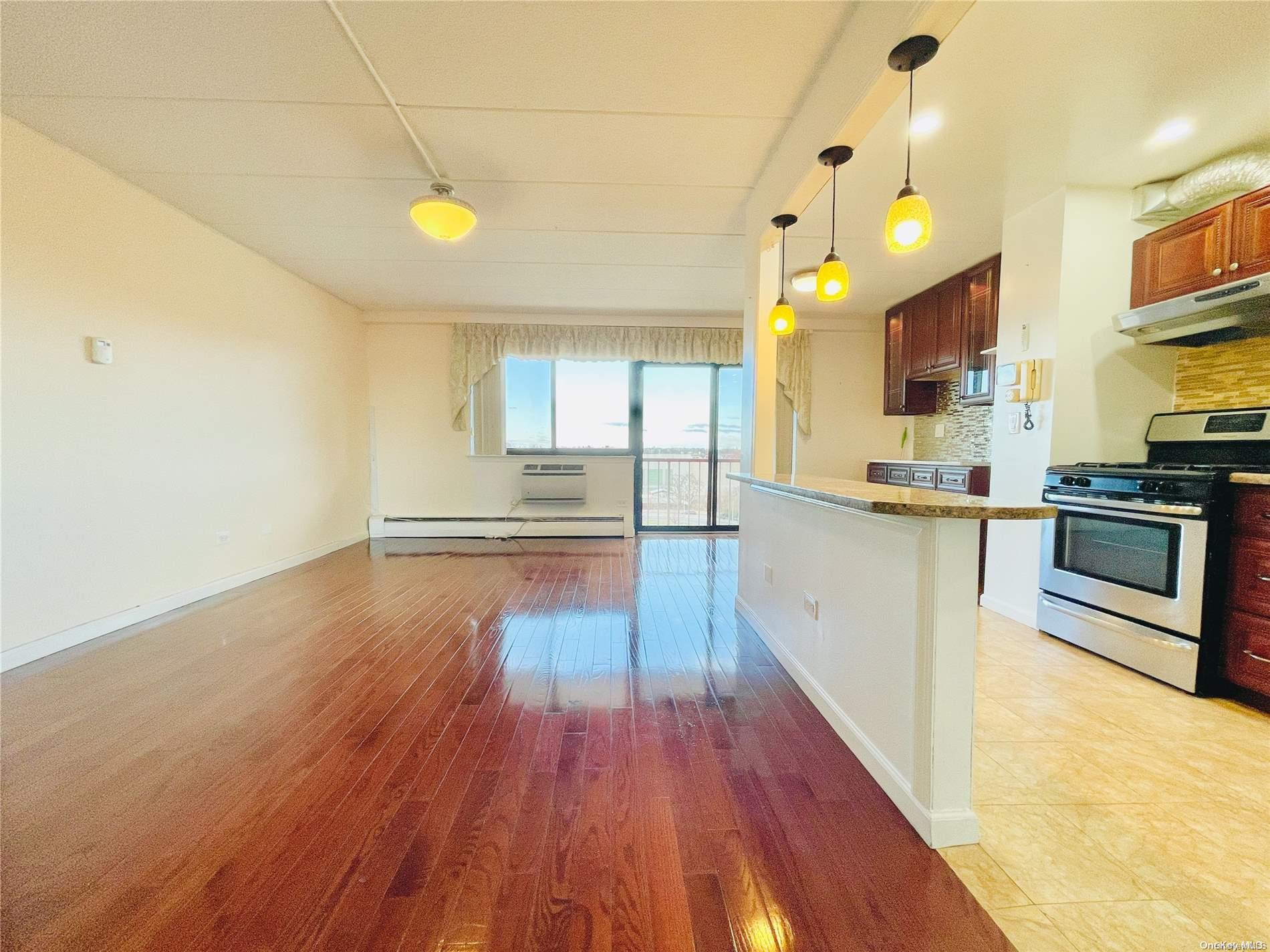 92-29 Queens Boulevard, Unit 9D Queens, NY 11374 - Photo 4 of 13 a view of a kitchen with kitchen island a sink wooden floor and stainless steel appliances