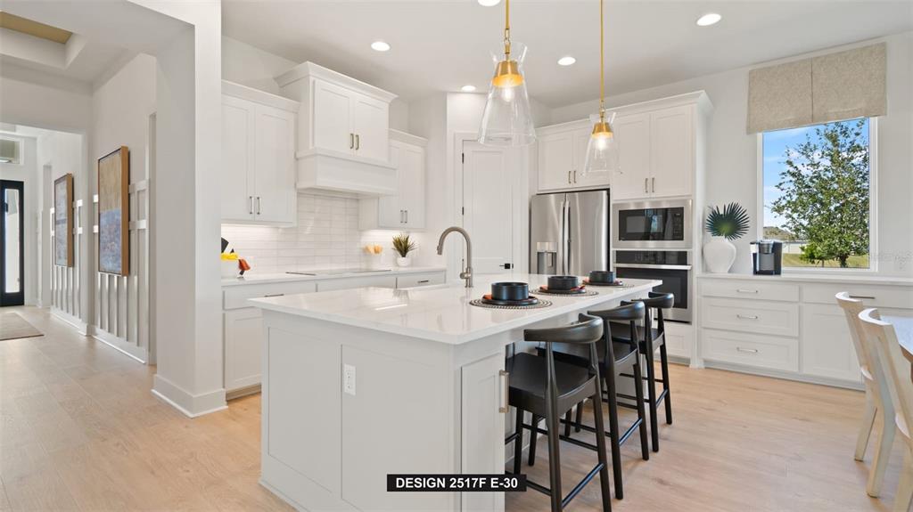 9531 Sandy Shores Street Parrish, FL 34219 - Photo 4 of 8 a kitchen with stainless steel appliances kitchen island granite countertop a sink and cabinets