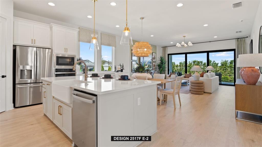 9531 Sandy Shores Street Parrish, FL 34219 - Photo 5 of 8 a kitchen with stainless steel appliances kitchen island granite countertop a sink and a refrigerator