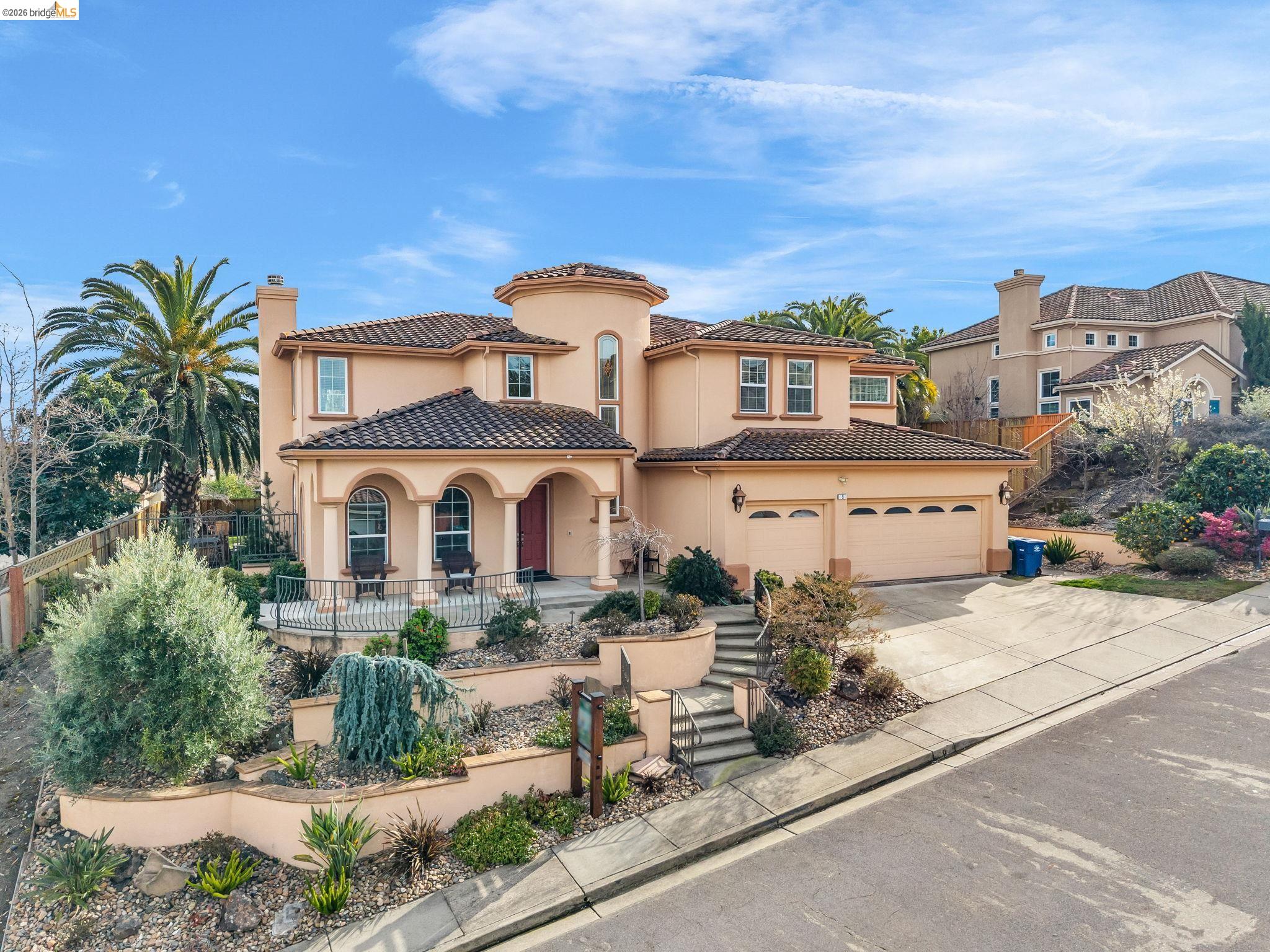 Mediterranean / spanish house featuring concrete driveway, a chimney, stucco siding, a patio, and a tiled roof