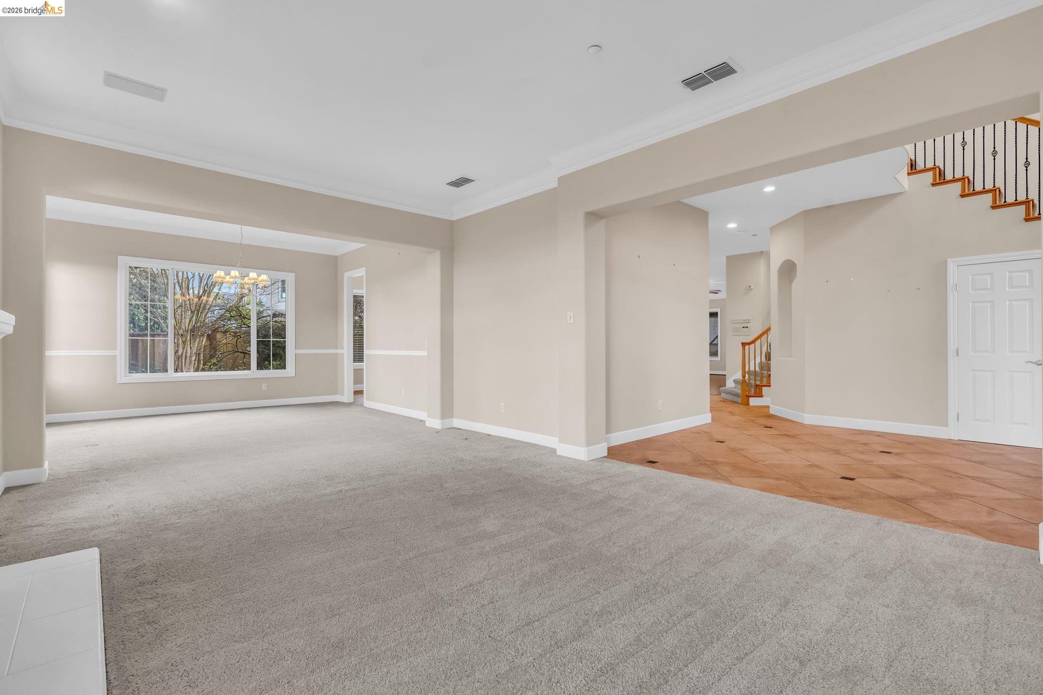 5 Circle E Ranch Place San Ramon, CA 94583 - Photo 15 of 60 Spare room featuring light carpet, crown molding, hanging lights, light tile patterned floors, and arched walkways