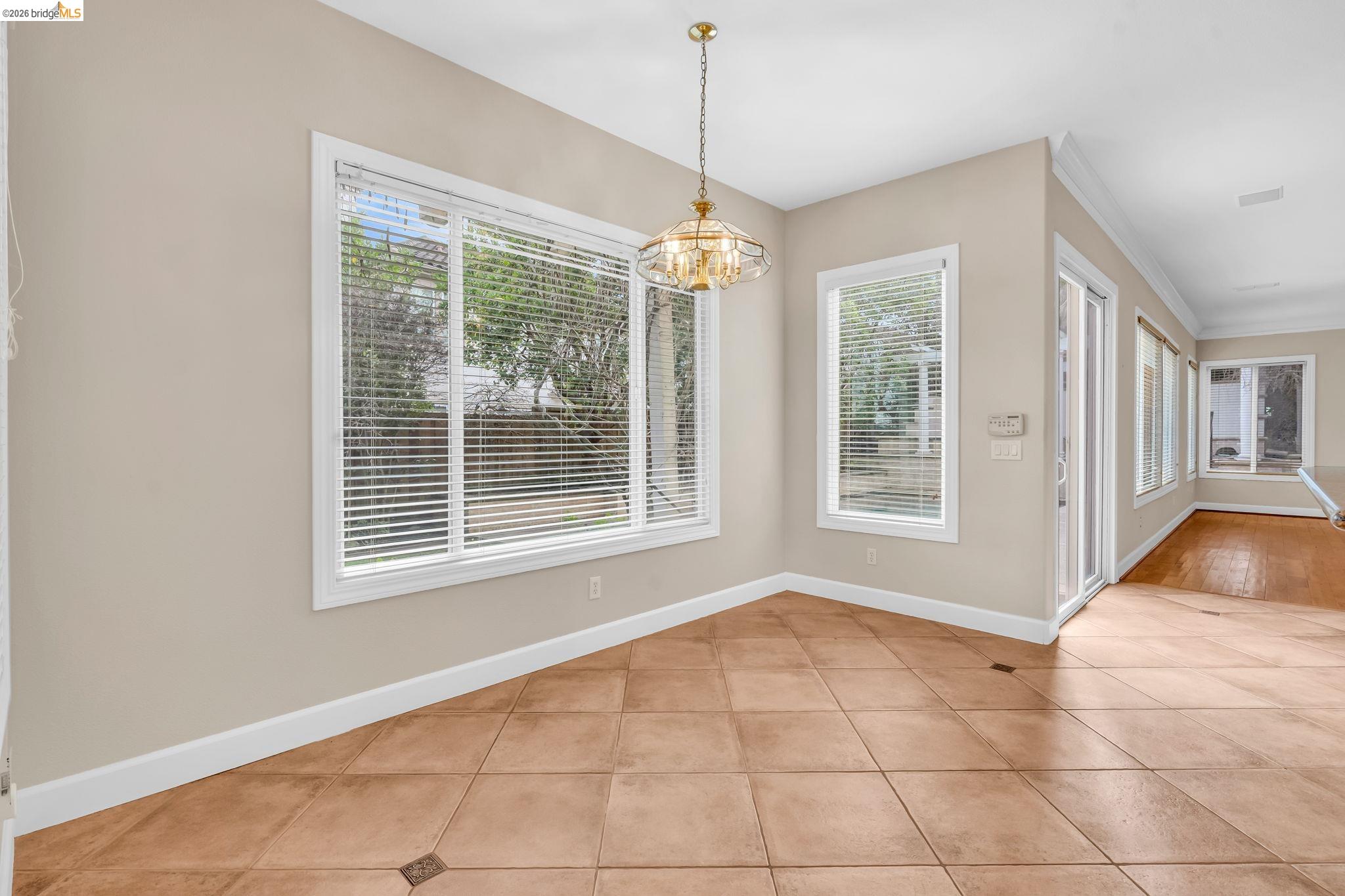 5 Circle E Ranch Place San Ramon, CA 94583 - Photo 18 of 60 Unfurnished dining area featuring light tile patterned floors, a chandelier, healthy amount of natural light, and ornamental molding