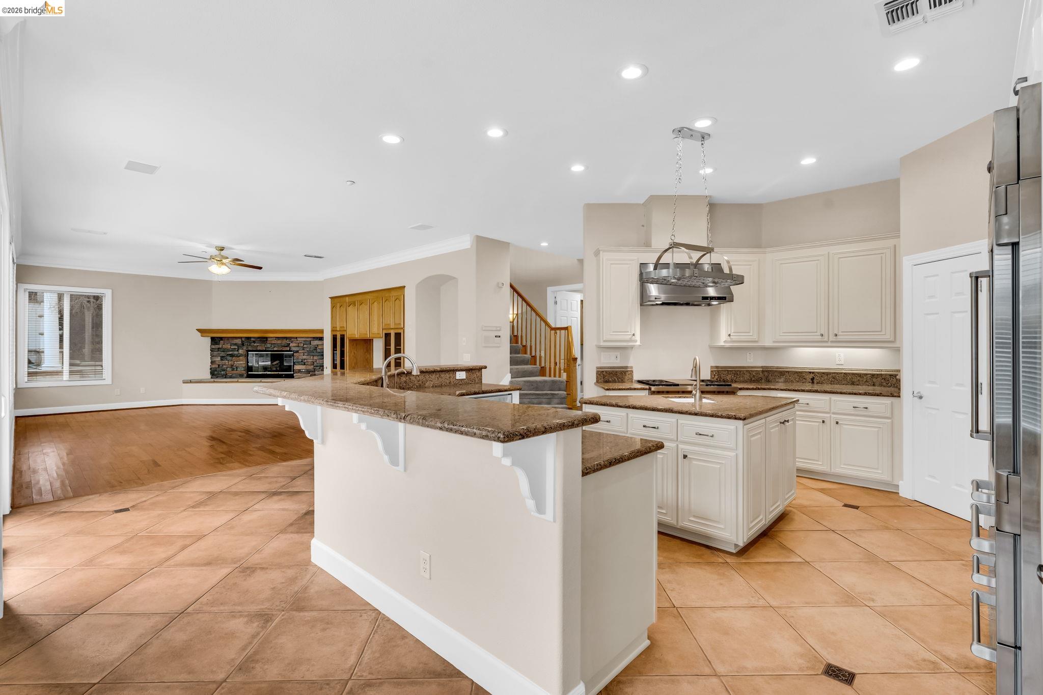 5 Circle E Ranch Place San Ramon, CA 94583 - Photo 60 of 60 Kitchen featuring light tile patterned floors, a breakfast bar area, open floor plan, a stone fireplace, and ceiling fan