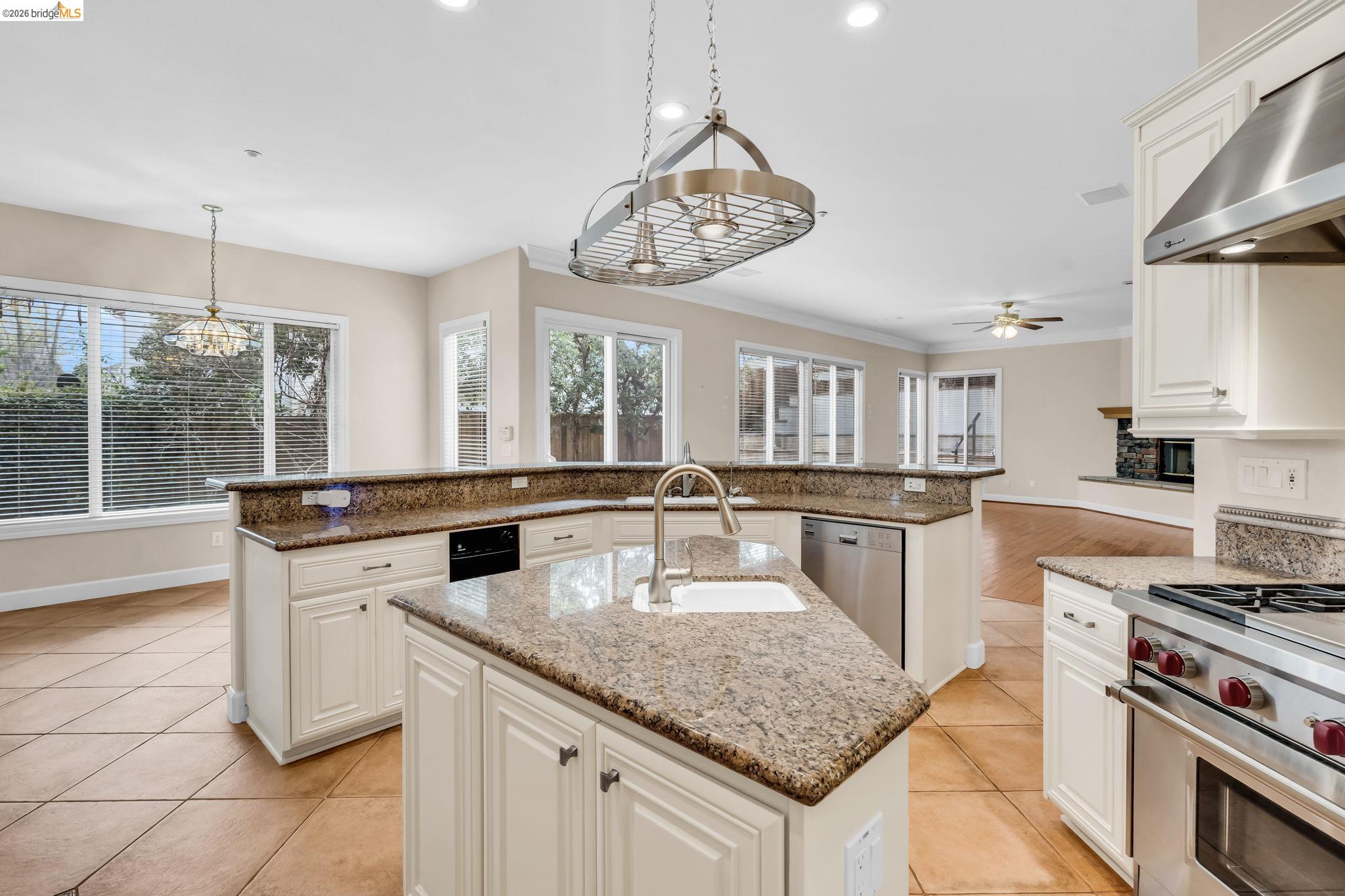 5 Circle E Ranch Place San Ramon, CA 94583 - Photo 48 of 60 Kitchen featuring white cabinetry, stainless steel appliances, range hood, light stone counters, and hanging light fixtures