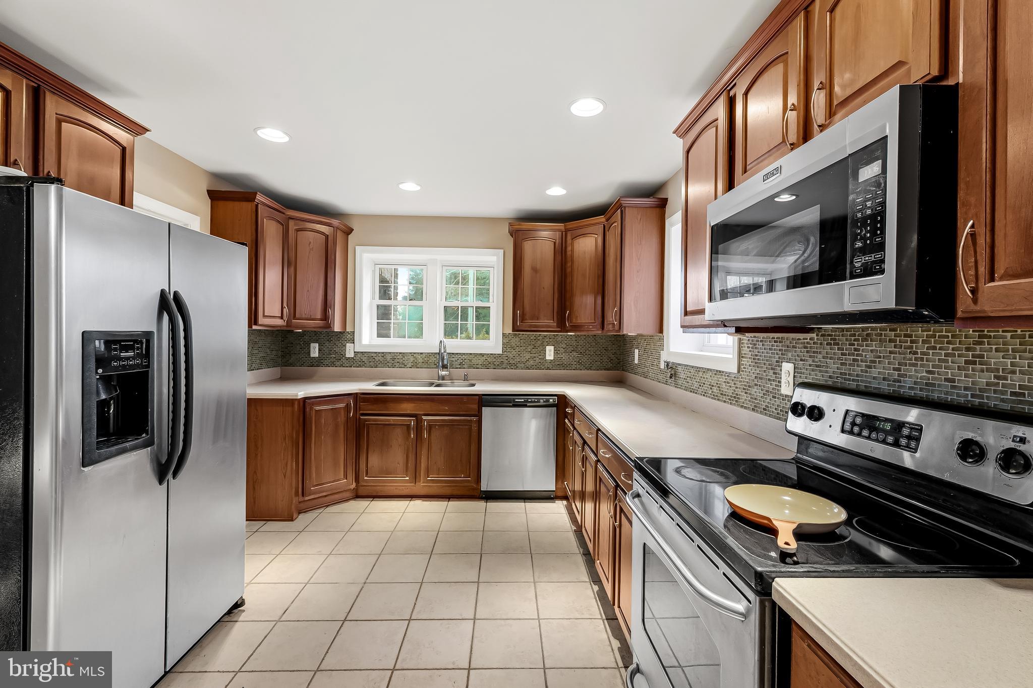 922 Fairway Drive Towson, MD 21286 - Photo 14 of 52 a kitchen with stainless steel appliances granite countertop a refrigerator and a stove top oven