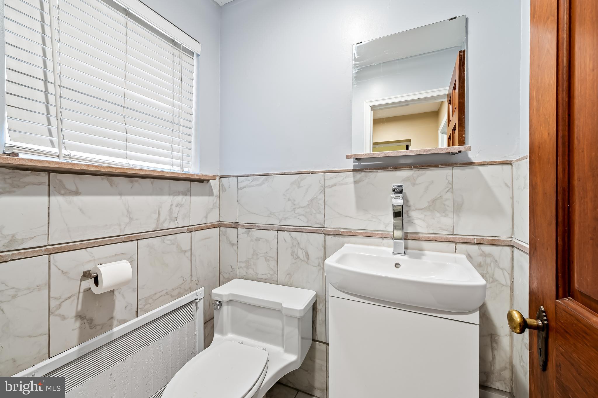922 Fairway Drive Towson, MD 21286 - Photo 21 of 52 a bathroom with a toilet a sink and mirror
