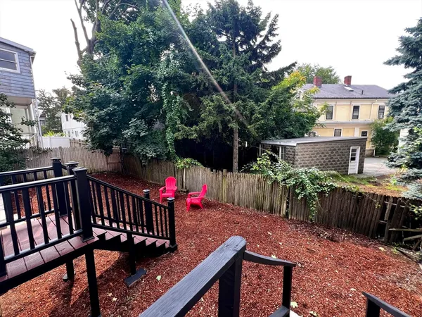 a view of a house with a yard and large trees