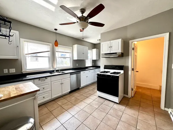 a kitchen with stainless steel appliances granite countertop a sink a stove a refrigerator a microwave oven with cabinets and wooden floor