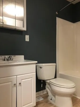 a bathroom with a toilet a sink and a mirror