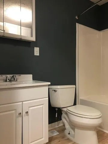 a bathroom with a toilet a sink and a mirror