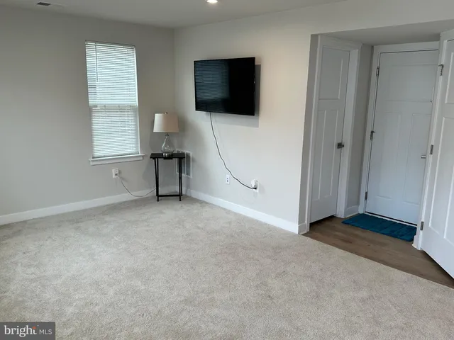 a view of an empty room with a window and a flat screen tv