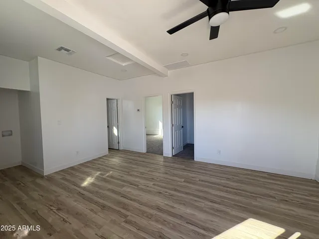 a view of an empty room with wooden floor
