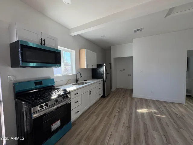 a kitchen with granite countertop a stove and a wooden floor