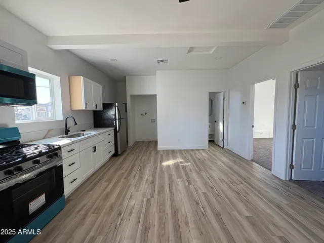 a large kitchen with a stove and wooden floor