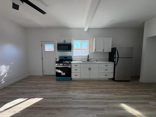 a kitchen with stainless steel appliances kitchen island granite countertop a stove and a refrigerator