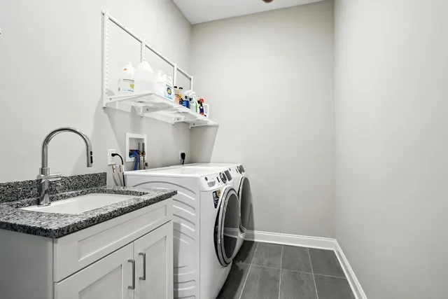 a utility room with sink dryer and washer