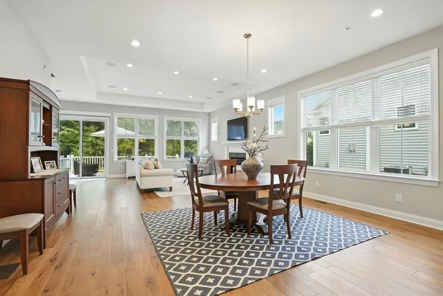 a living room with furniture a large window and wooden floor