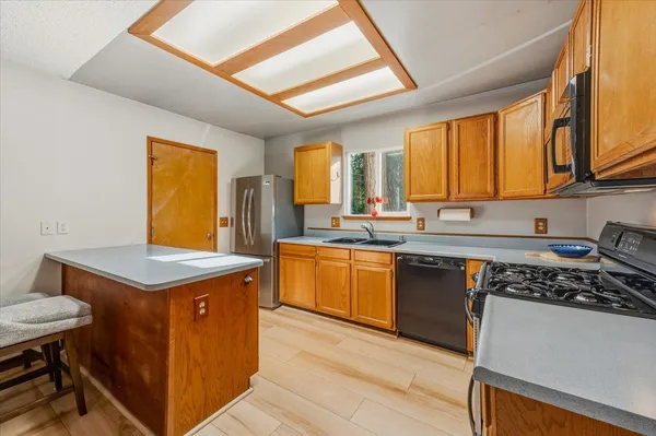 a kitchen with stainless steel appliances granite countertop a stove a sink dishwasher and a refrigerator