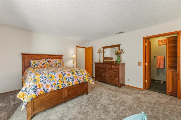 a large bed sitting in a bedroom next to a cabinet