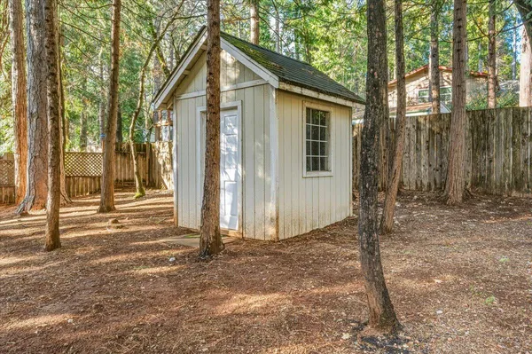 a view of a house with backyard and trees